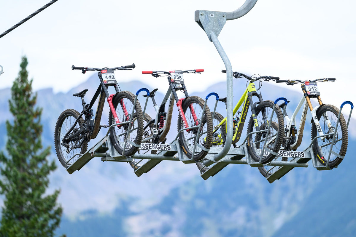 Bikes ride the chairlift up Purgatory with the mountains behind