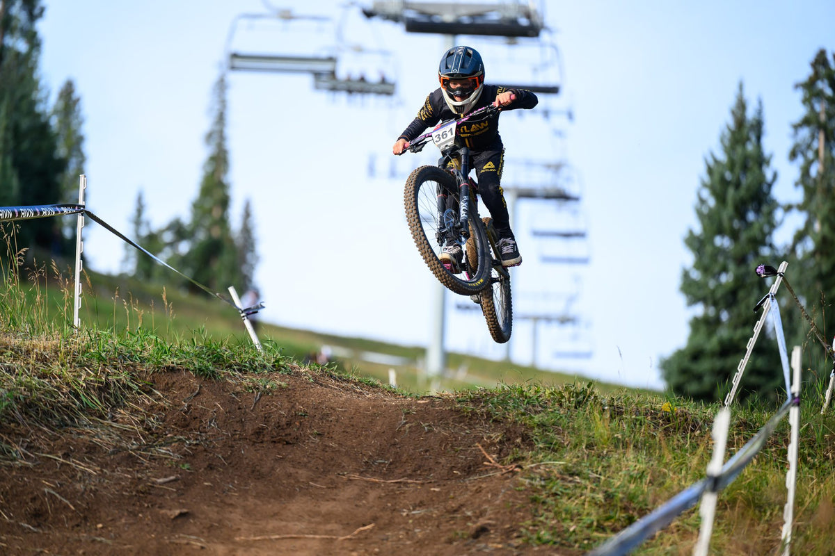 A rider in the air under the chairlift at Purgatory