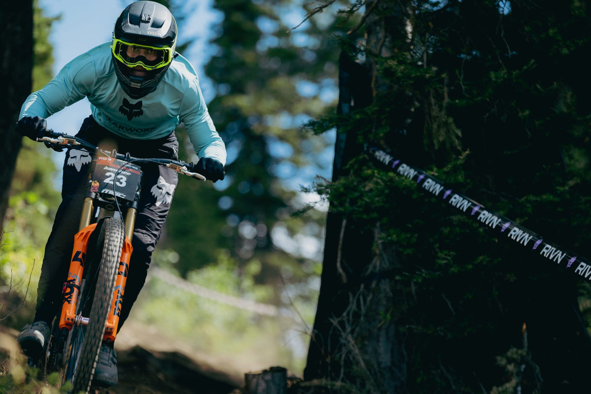 A rider in a mint jersey through the trees at Grand Targhee