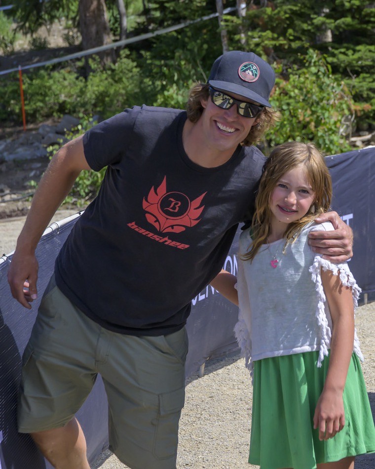 Brian Buell of Banshee Bikes with his arm around a young racer at a Mountain States Cup round